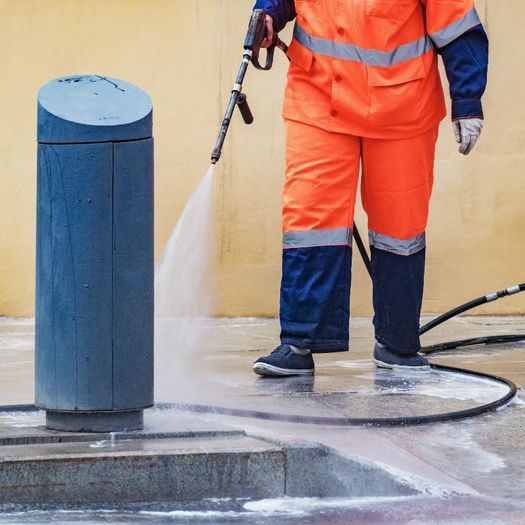 Trabajador limpiando con pistola de agua a presión